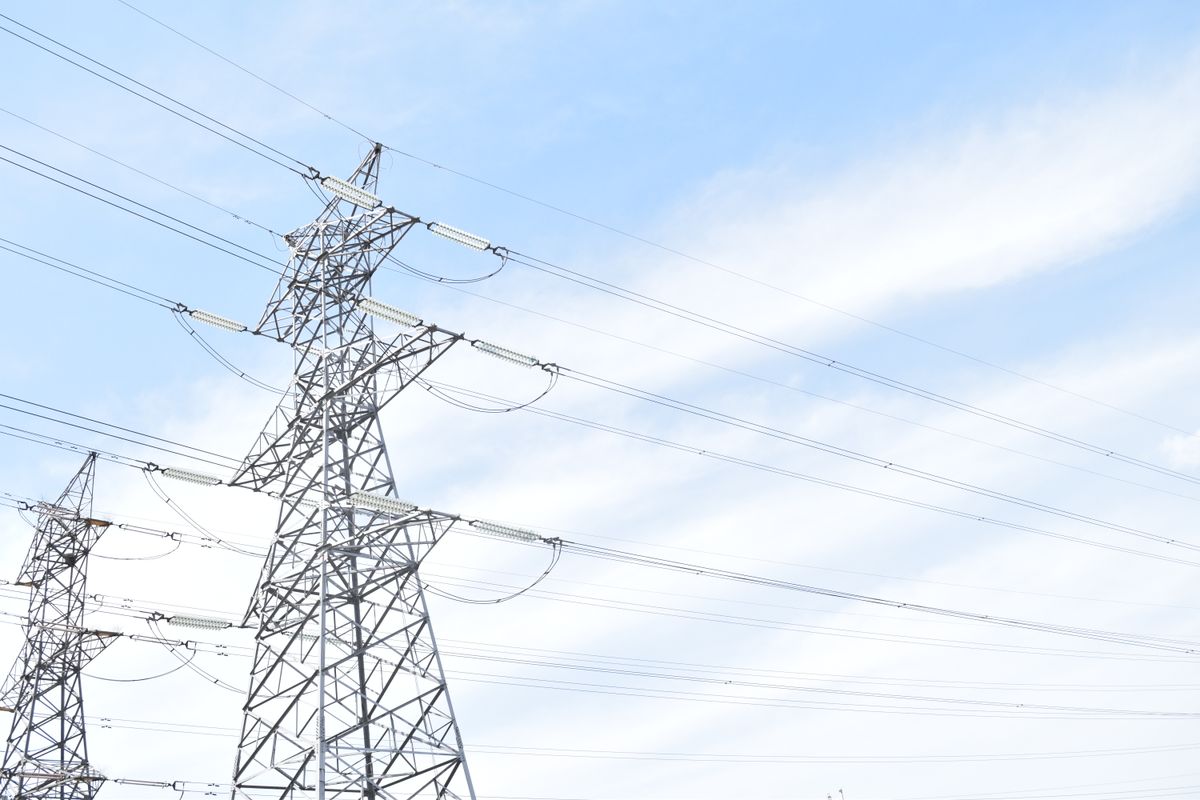 High-voltage transmission line towers stretching across open terrain